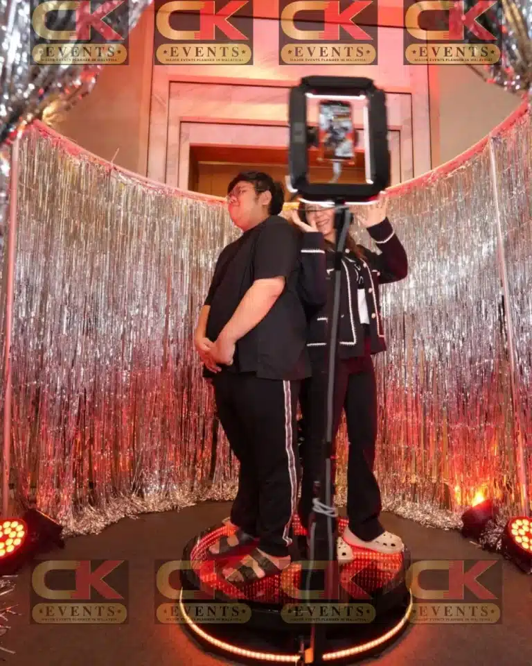 Guests on CK Event Management 360 video booth with silver tinsel shimmer backdrop – social, wedding and corporate photobooth rental in Malaysia.