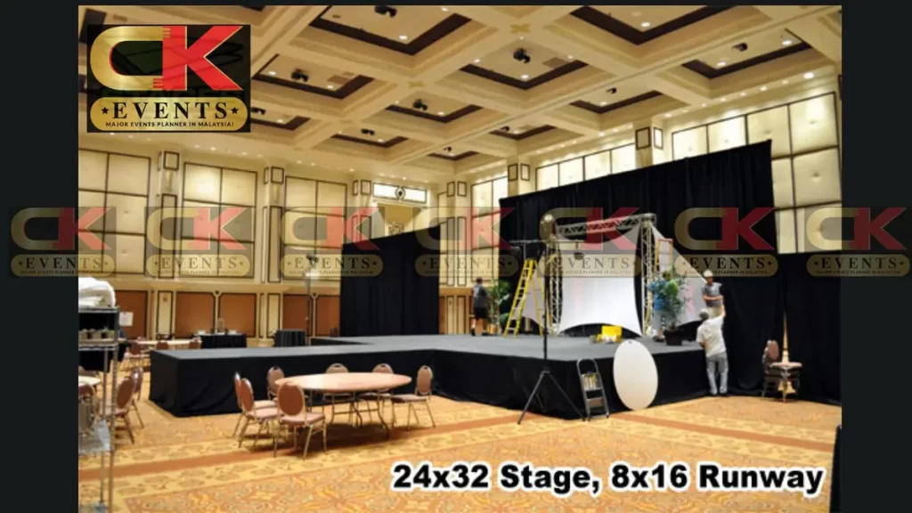 Black and white fabric-draped fashion runway stage with T-shaped catwalk and draped backdrop