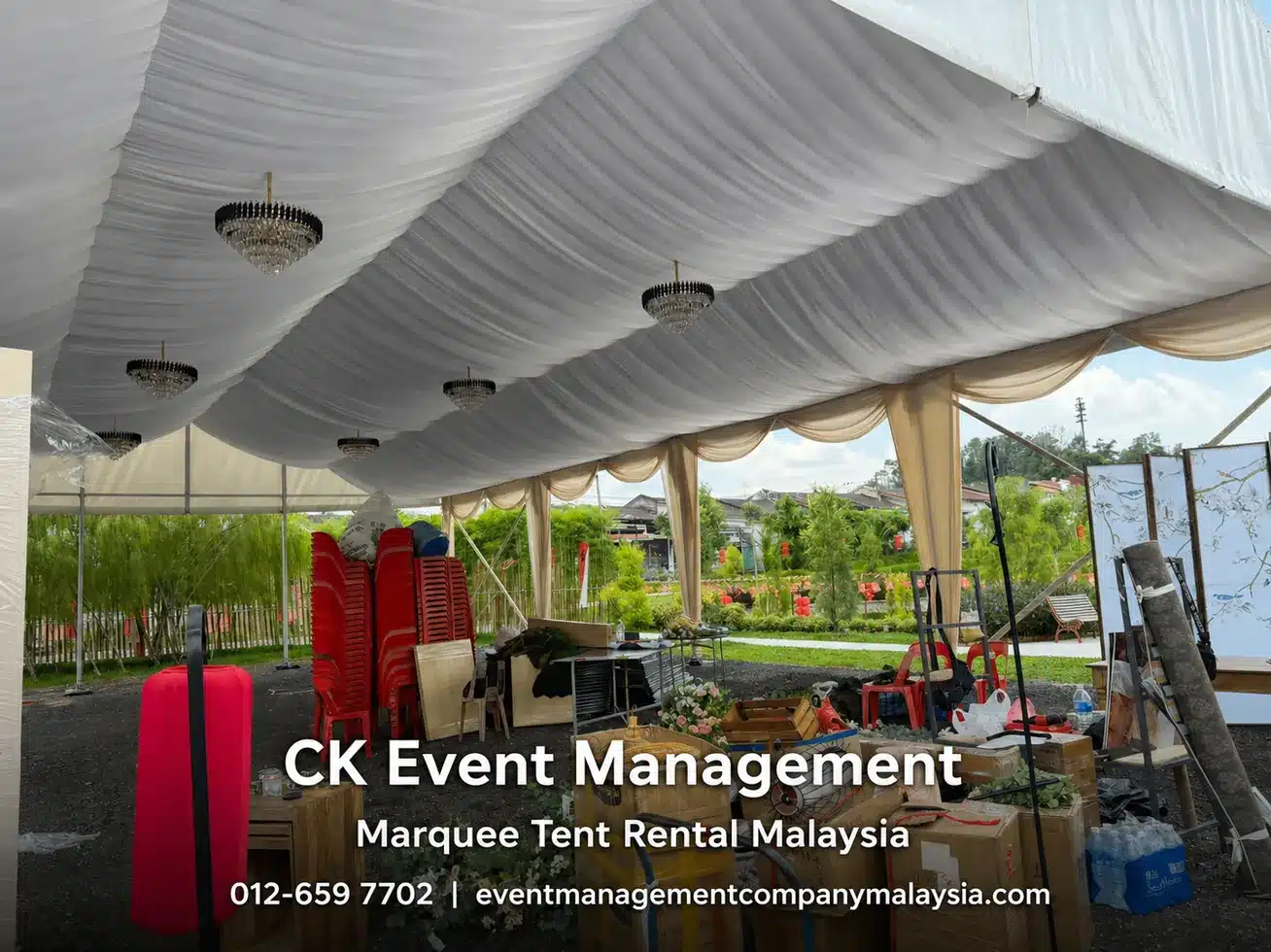 Draped marquee interior with chandeliers and event setup equipment