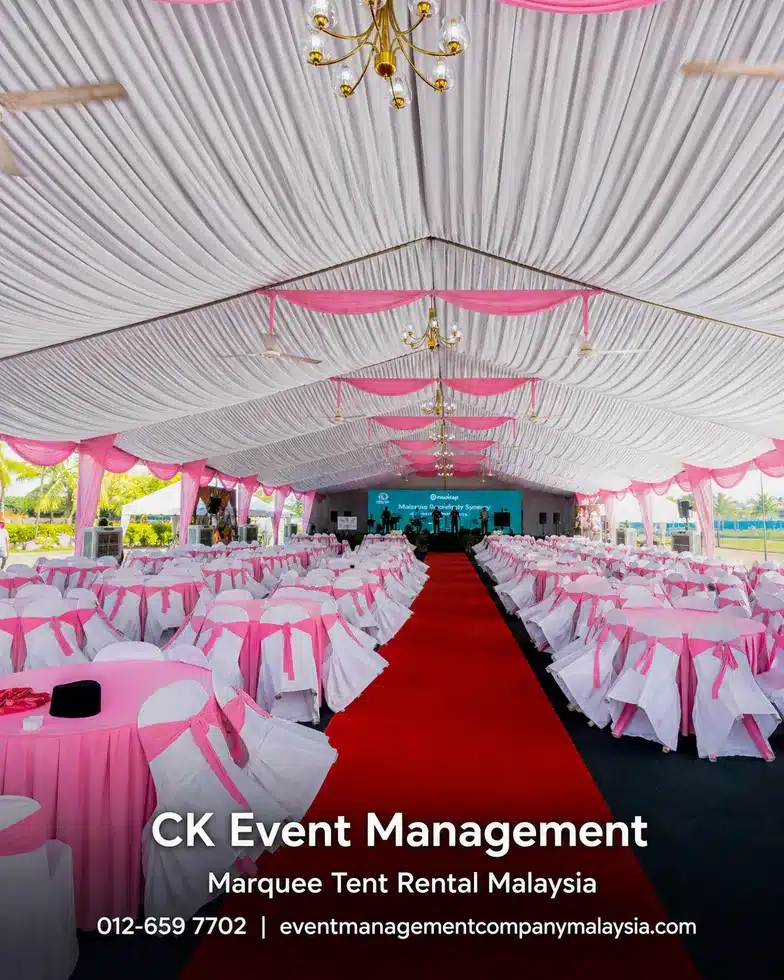 Pink and white draped marquee banquet interior with red carpet and stage