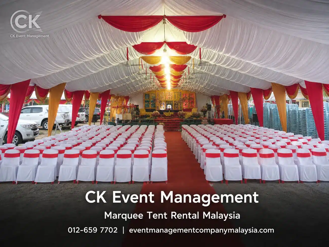 Red and gold draped marquee seating layout with rows of covered chairs