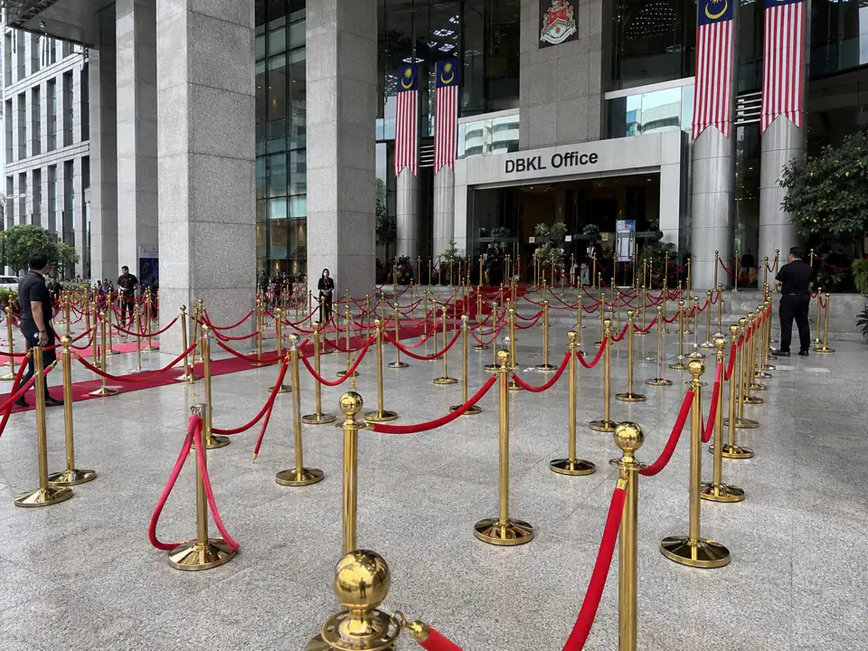 Large gold stanchion and red rope VIP queue pole deployment at DBKL office entrance in Kuala Lumpur