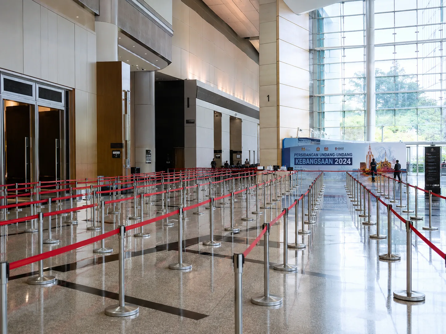 Silver Q pole with red belt large event registration queue at a Malaysian convention centre